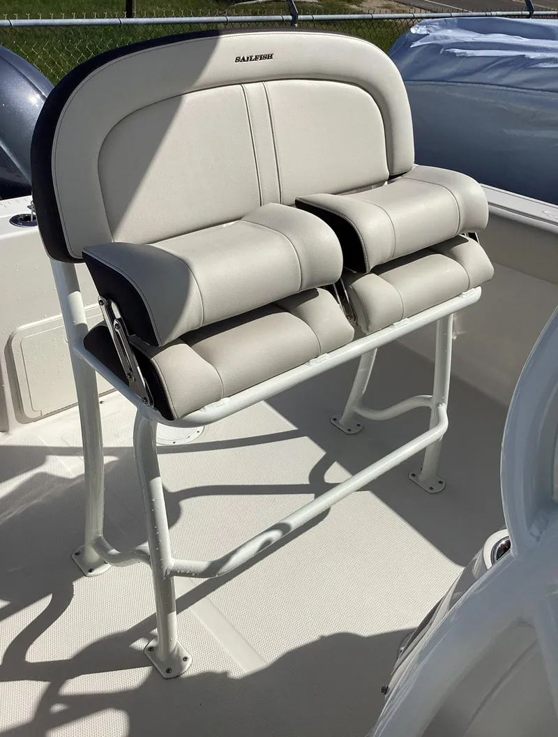 Slide: The Image of 2022 Sailfish 220 CC boat seating, featuring dual cushioned seats and sturdy metal frame. - 4