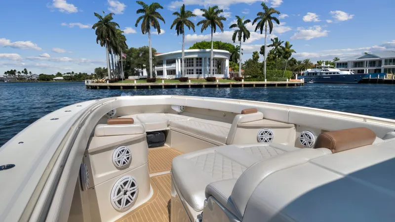 Slide: The Image of Luxury 2018 HCB 53 Sueños boat with spacious seating, cruising near waterfront homes and palm trees. - 14