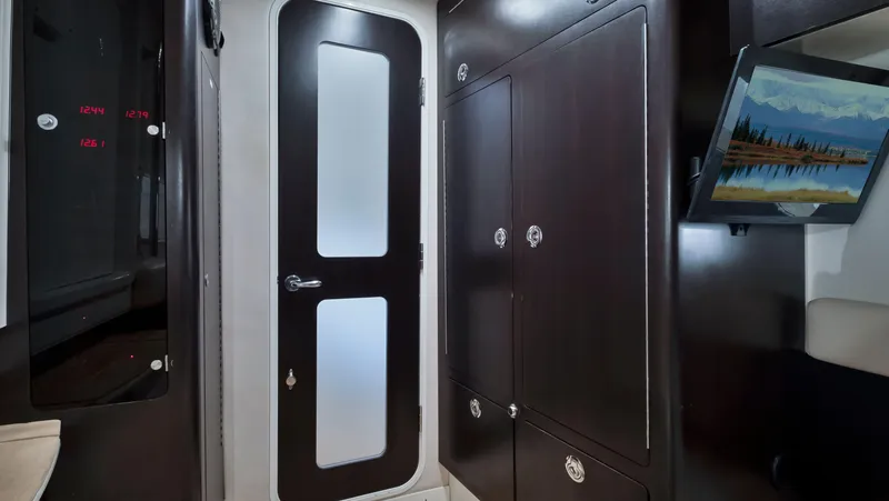 Slide: The Image of Interior of 2018 HCB 53 Sueños yacht with dark wood cabinets and frosted glass door. - 26