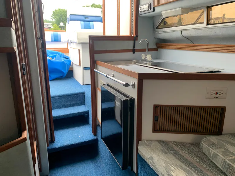 Slide: The Image of Interior of 1989 Sea Ray 230 Weekender boat with kitchenette and blue carpet. - 10