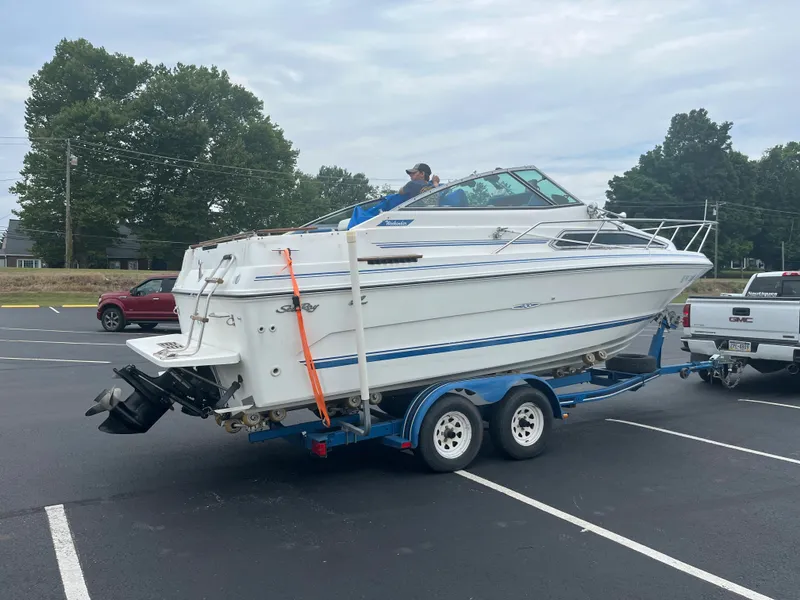 Slide: The Image of 1989 Sea Ray 230 Weekender boat on a trailer in a parking lot. - 3