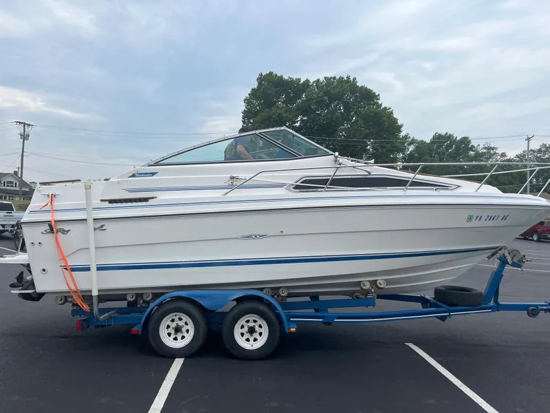 Slide: The Image of 1989 Sea Ray 230 Weekender boat on a trailer in a parking lot. - 5