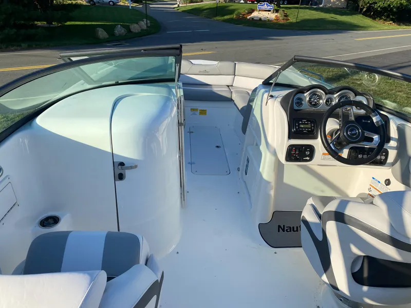 Slide: The Image of 2023 NauticStar 243DC Sport Deck boat interior with steering console and seating. - 4