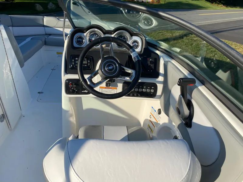 Slide: The Image of 2023 NauticStar 243DC Sport Deck boat cockpit with steering wheel and control panel. - 5