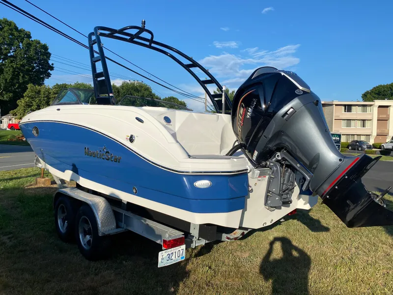 Slide: The Image of 2023 NauticStar 243DC Sport Deck boat on a trailer, blue and white exterior. - 8