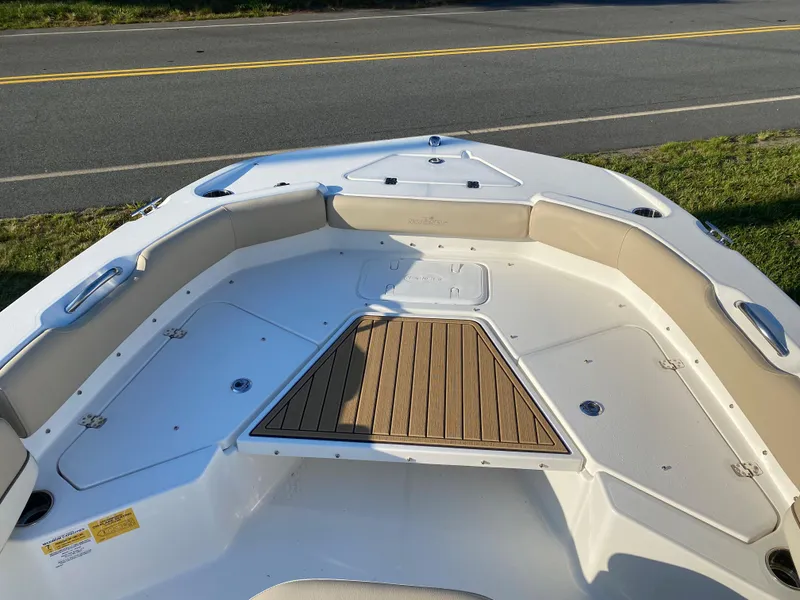 Slide: The Image of 2023 NauticStar 243DC Sport Deck boat bow with seating and storage compartments. - 9