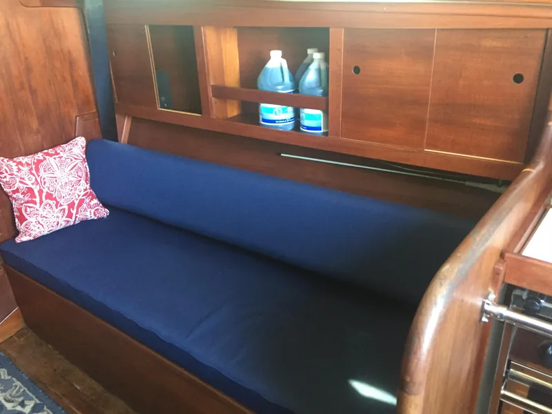 Slide: The Image of Interior of 1980 Tartan 33 sailboat with blue cushioned seating and wooden cabinetry. - 15