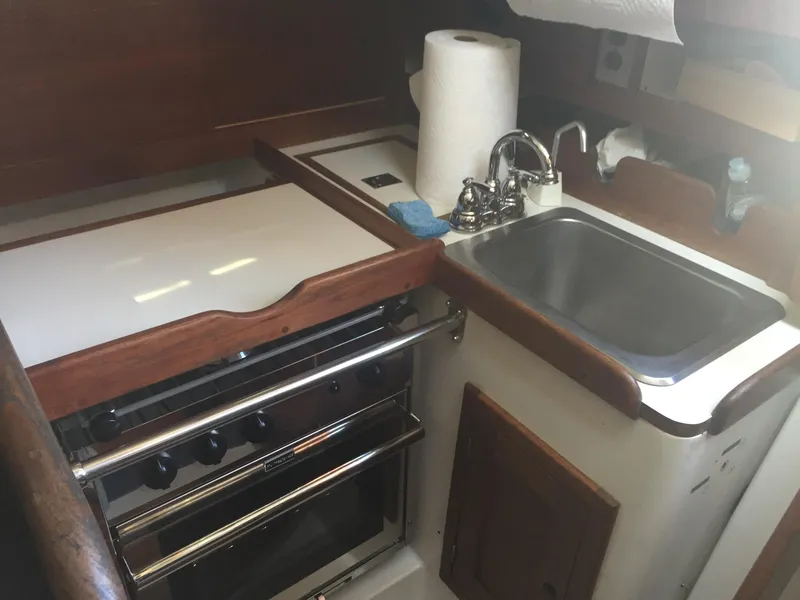 Slide: The Image of Compact kitchen area in a 1980 Tartan 33 sailboat with stove and sink. - 16