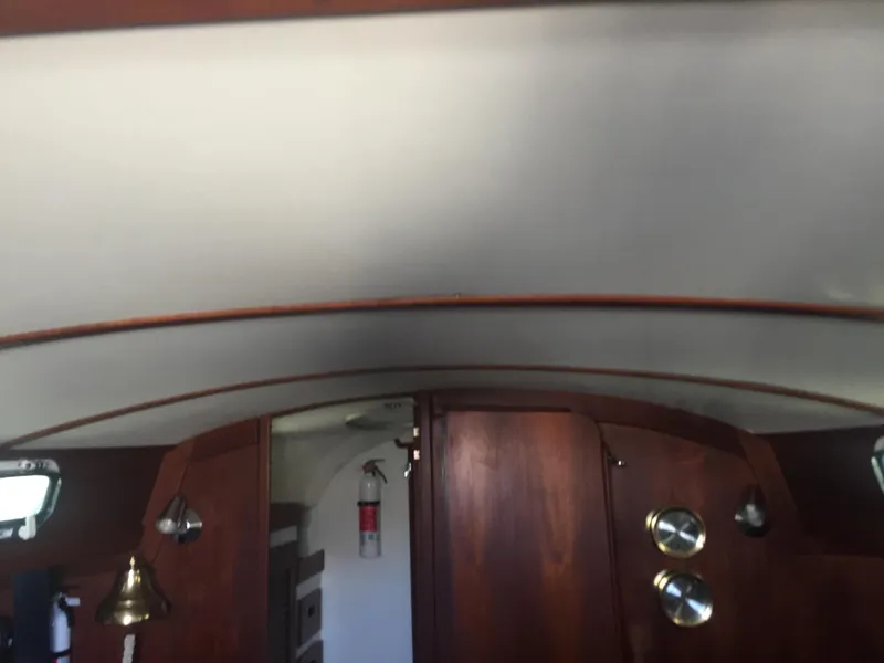 Slide: The Image of Interior of a 1980 Tartan 33 sailboat with wooden cabinetry and nautical decor. - 17