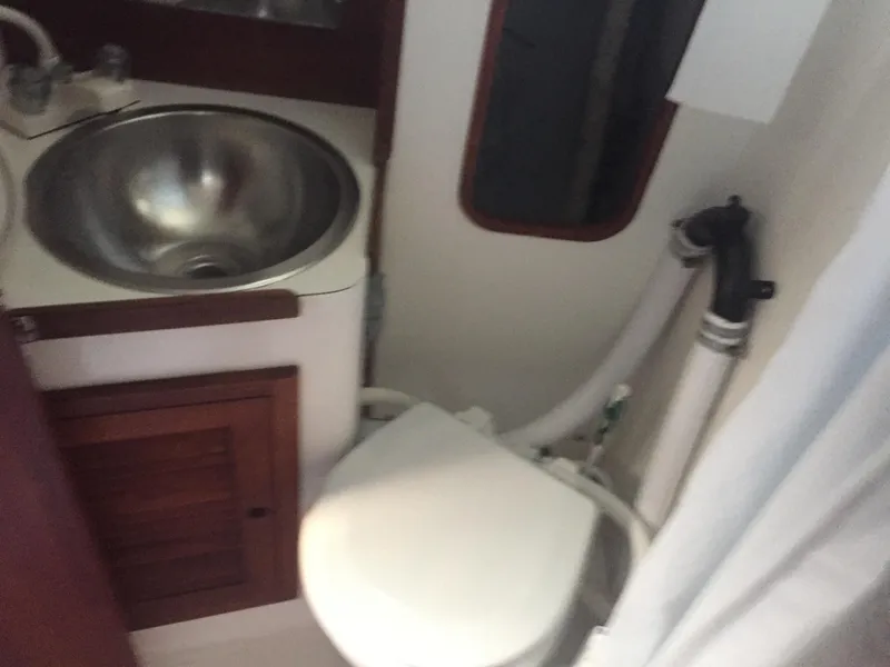 Slide: The Image of Compact bathroom in a 1980 Tartan 33 sailboat with sink and toilet. - 20
