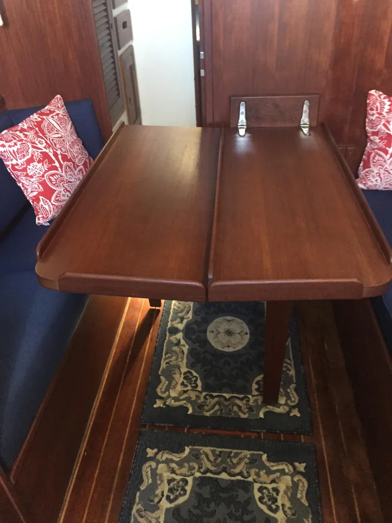 Slide: The Image of 1980 Tartan 33 sailboat interior with wooden table and blue seating. - 24