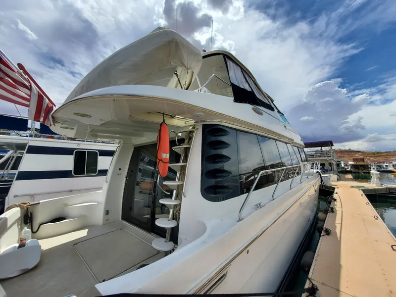 Slide: The Image of 2003 Carver 570 Voyager Pilothouse yacht docked at marina under cloudy sky. - 19