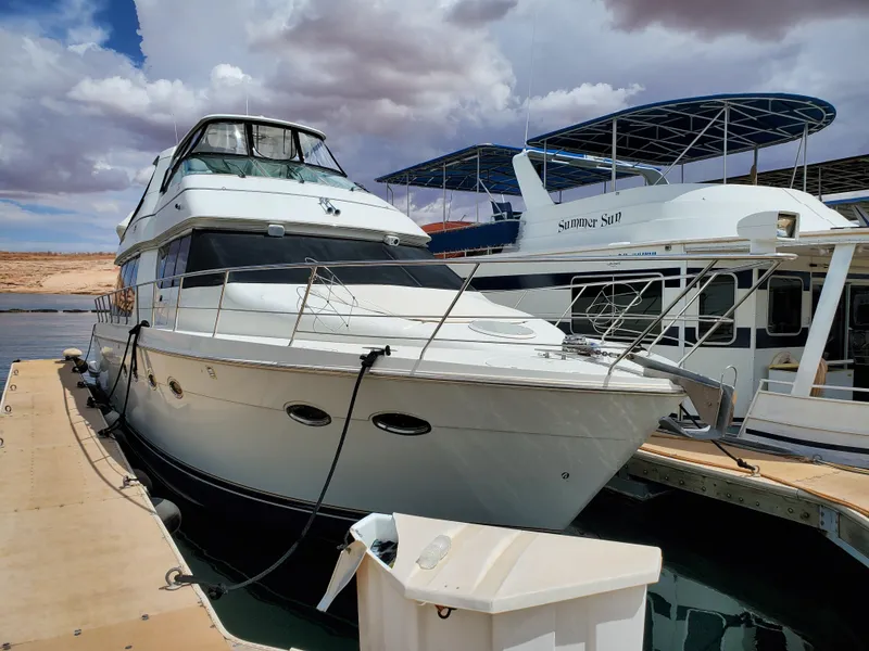 Slide: The Image of 2003 Carver 570 Voyager Pilothouse docked at marina under cloudy sky. - 2