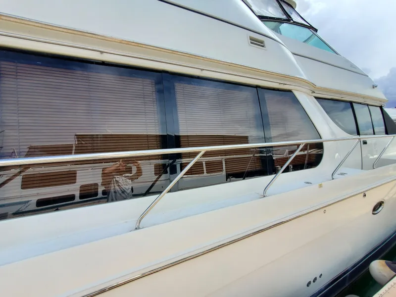 Slide: The Image of 2003 Carver 570 Voyager Pilothouse yacht exterior with large windows and sleek design. - 20