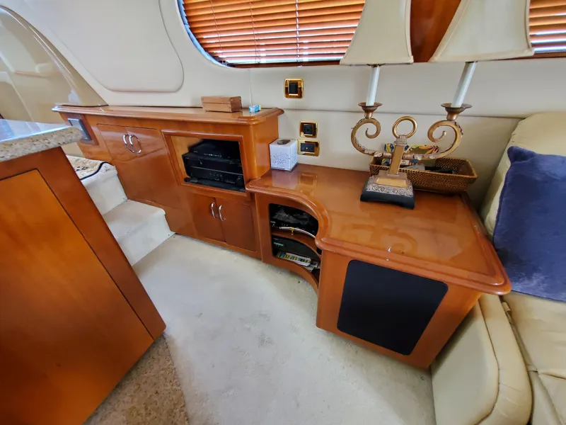 Slide: The Image of 2003 Carver 570 Voyager Pilothouse interior with wooden cabinetry and entertainment center. - 37