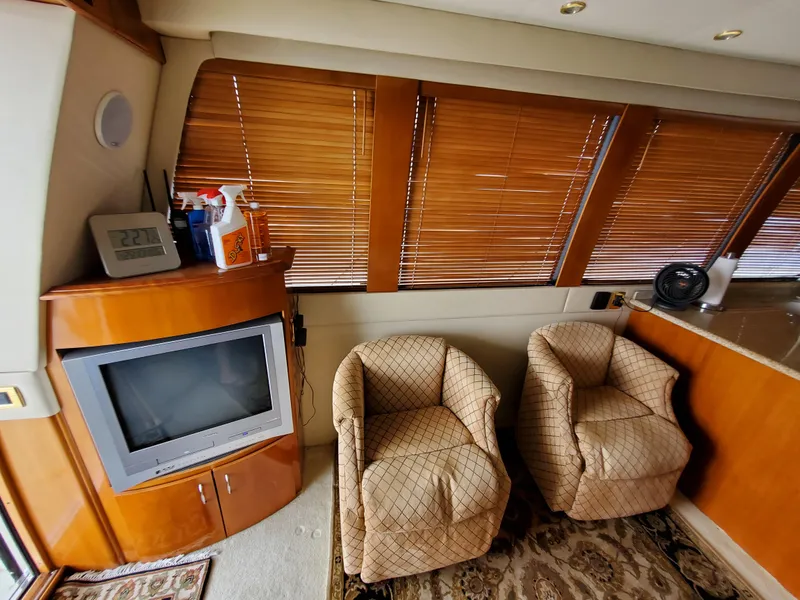 Slide: The Image of Interior of 2003 Carver 570 Voyager Pilothouse with TV, chairs, and wooden blinds. - 38