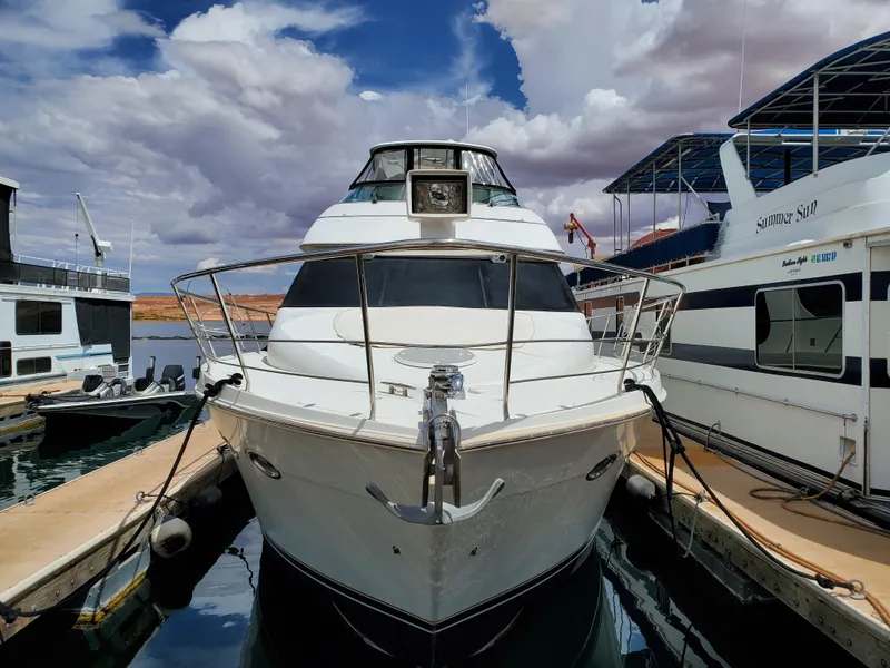Slide: The Image of 2003 Carver 570 Voyager Pilothouse docked between boats under cloudy sky. - 4