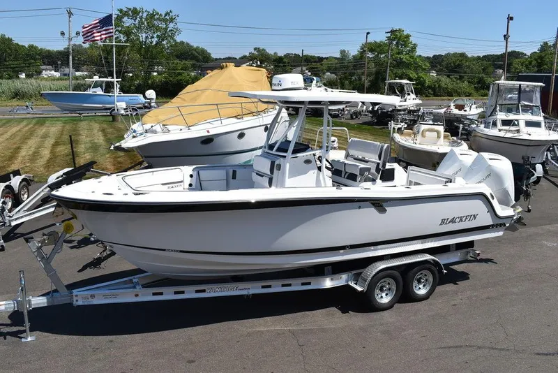 Slide: The Image of 2023 Blackfin 252CC boat on a trailer in a marina. - 2
