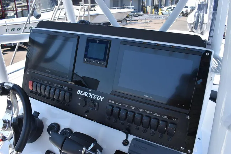 Slide: The Image of 2023 Blackfin 252CC boat dashboard with dual Garmin displays and control switches. - 32