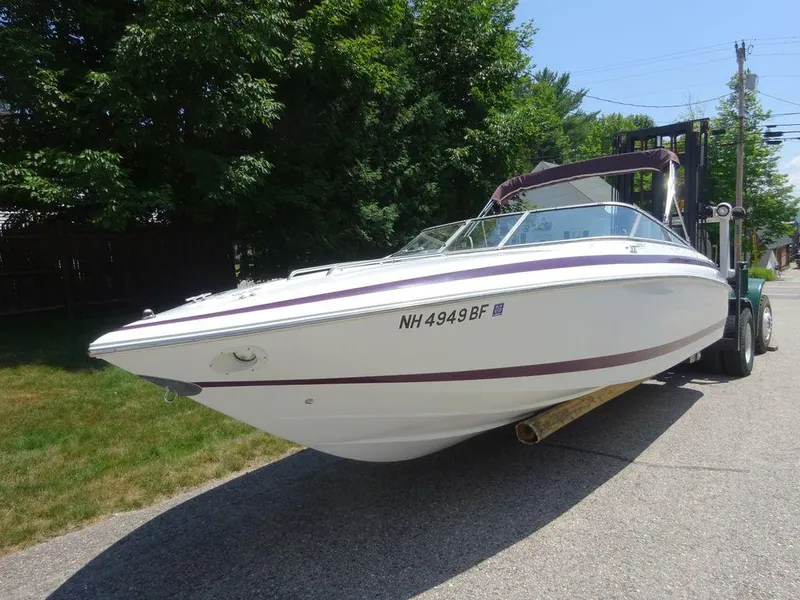 Slide: The Image of 1999 Cobalt 253 boat on trailer, white with maroon stripe, parked on street. - 10