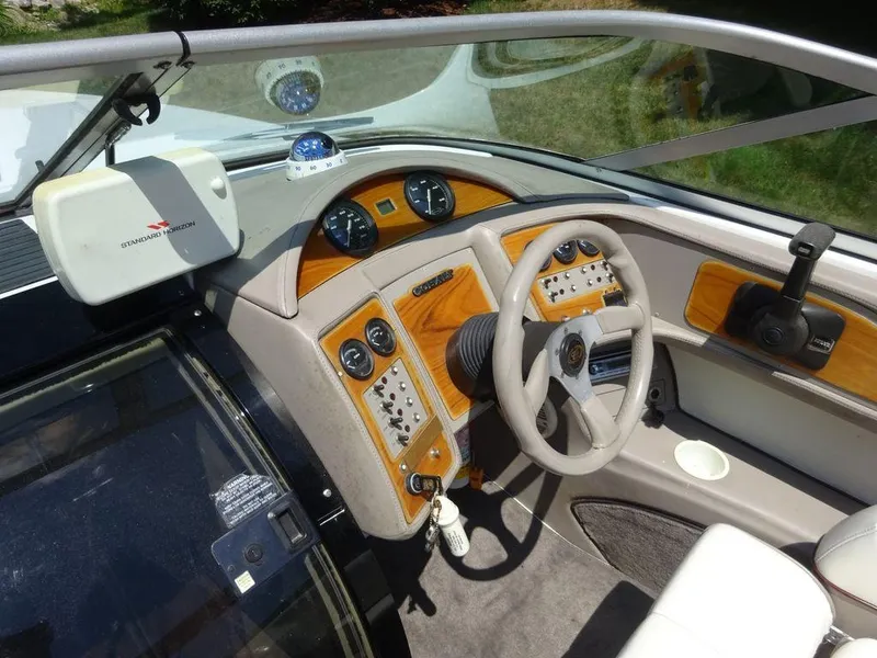 Slide: The Image of 1999 Cobalt 253 boat dashboard with steering wheel and control panel. - 13
