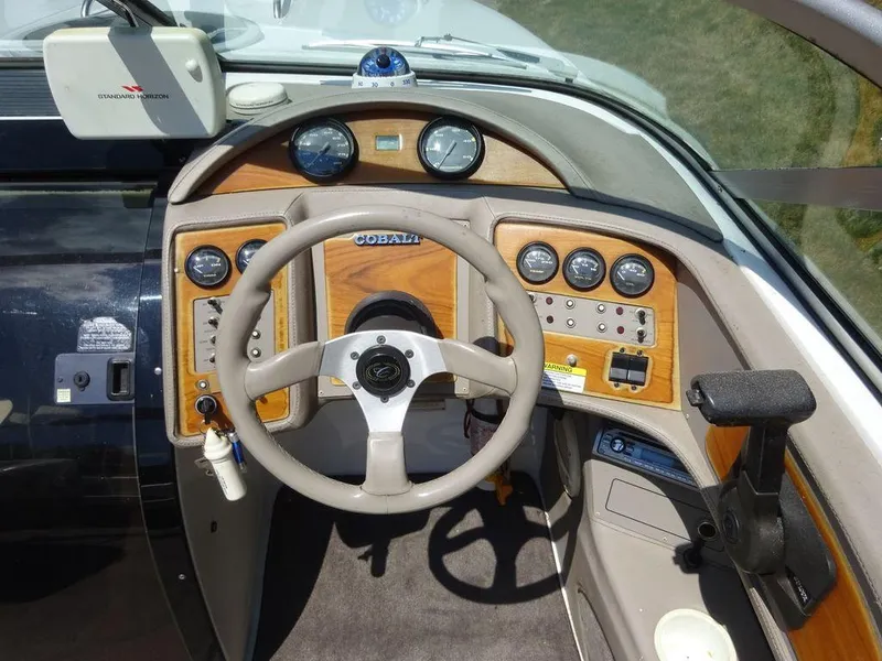Slide: The Image of 1999 Cobalt 253 boat dashboard with steering wheel and control panel. - 14