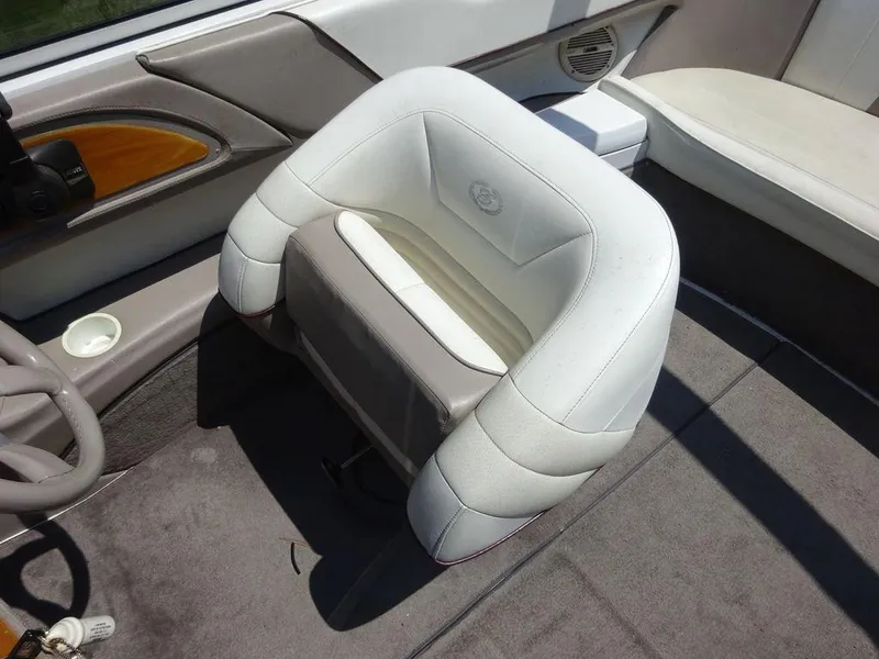 Slide: The Image of Captain's seat in a 1999 Cobalt 253 boat, featuring white and gray upholstery. - 3