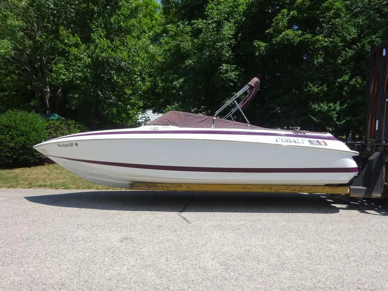Slide: The Image of 1999 Cobalt 253 boat on trailer, white with maroon accents, parked outdoors. - 8