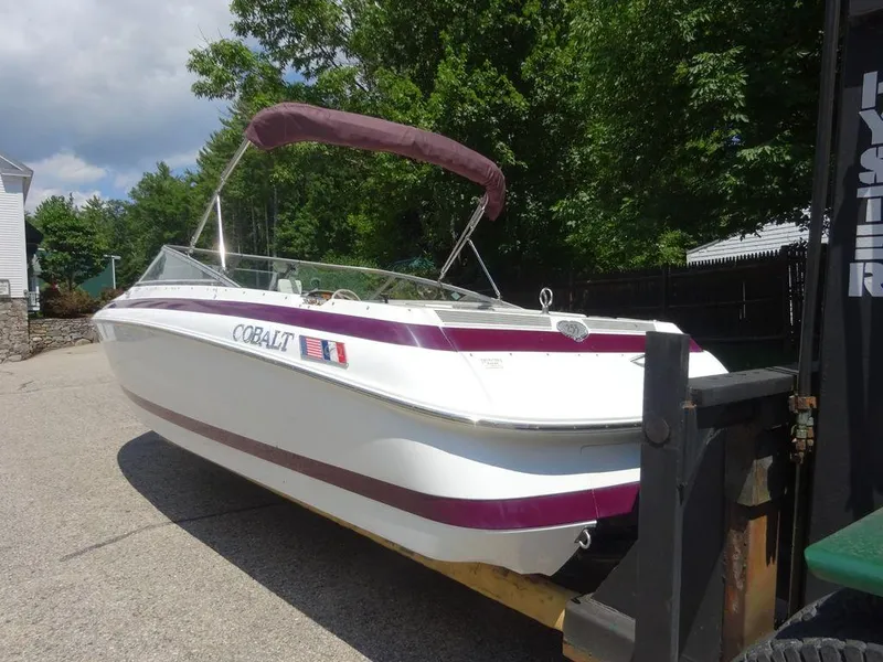 Slide: The Image of 1999 Cobalt 253 boat with maroon accents on a trailer. - 9