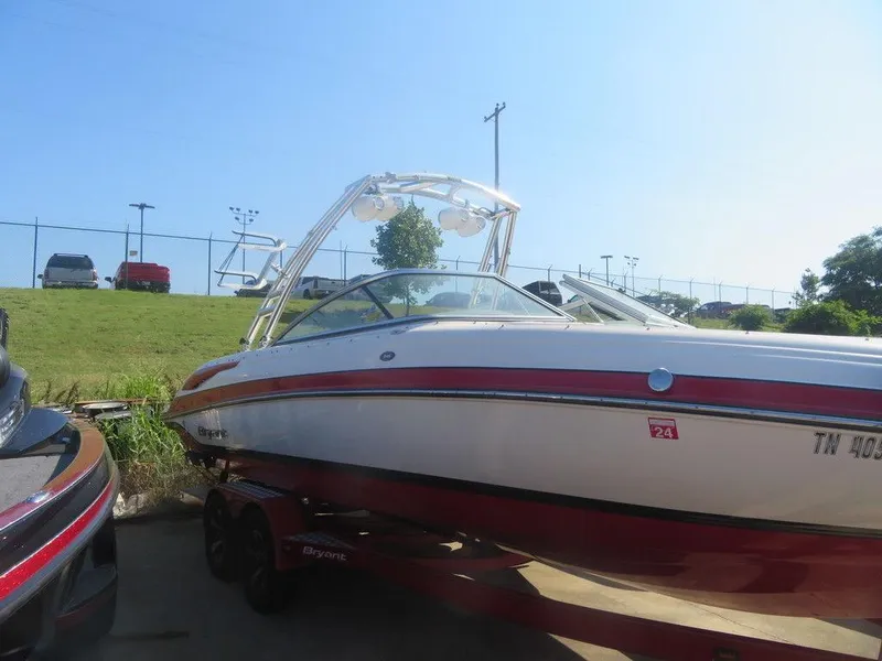 Slide: The Image of 2012 Bryant 246 boat with red and white exterior on a trailer. - 0