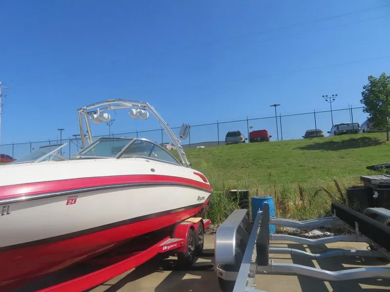 Slide: The Image of 2012 Bryant 246 boat on a trailer in a parking lot. - 12