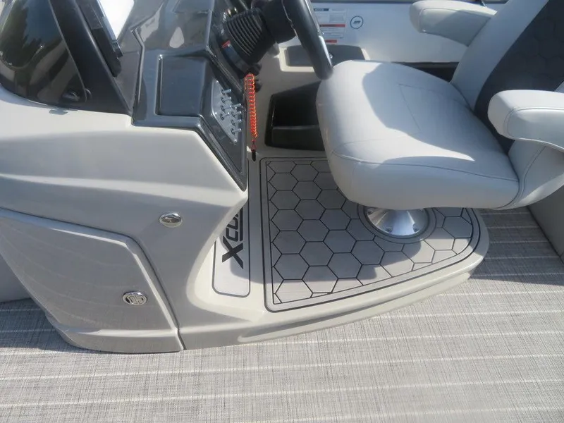 Slide: The Image of 2020 Xcursion 245 Sport Toon boat interior with captain's chair and dashboard. - 10