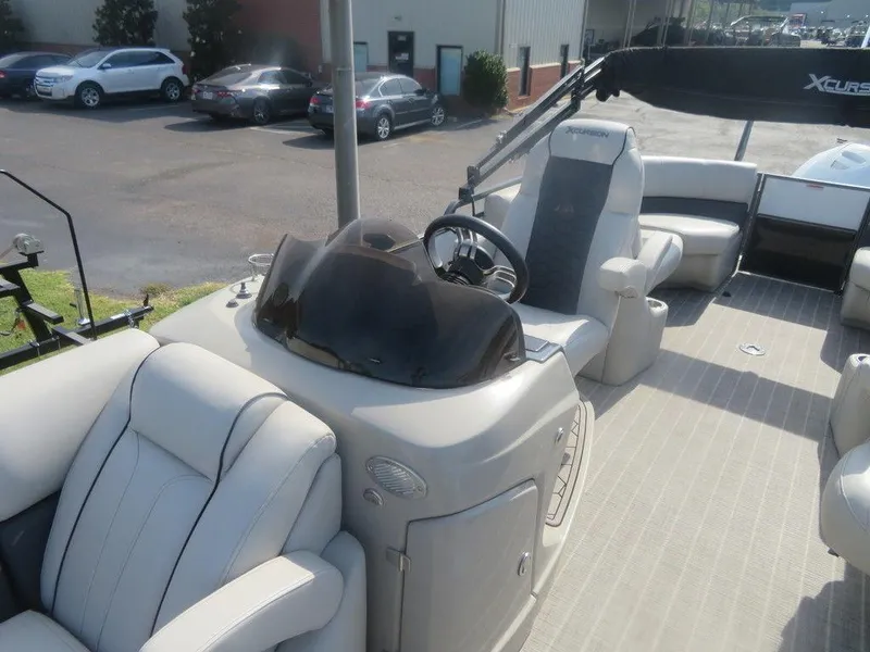 Slide: The Image of 2020 Xcursion 245 Sport Toon boat interior with steering console and seating. - 18