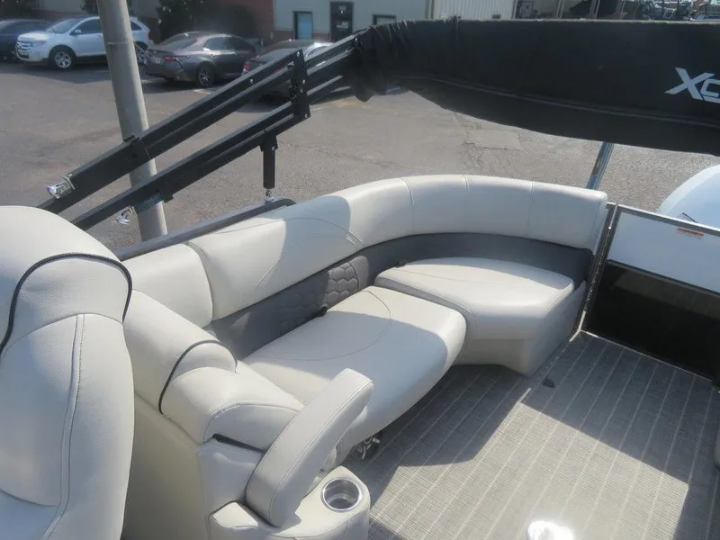 Slide: The Image of 2020 Xcursion 245 Sport Toon boat interior with plush seating and trailer. - 4