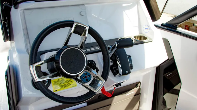 Slide: The Image of 2023 Axopar 22 T-Top boat steering wheel and control panel. - 10