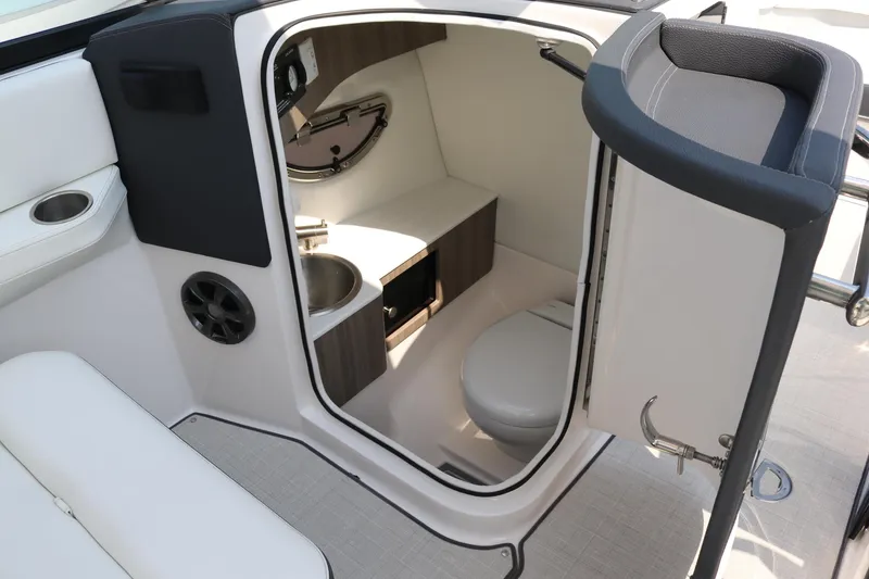 Slide: The Image of 2023 Regal LS6 boat interior with compact bathroom, featuring sink and toilet. - 9