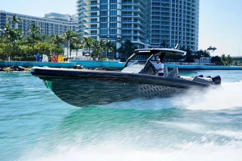 Slide: The Image of 2024 Skipper-BSK 38NC speedboat cruising near modern waterfront buildings. - 0