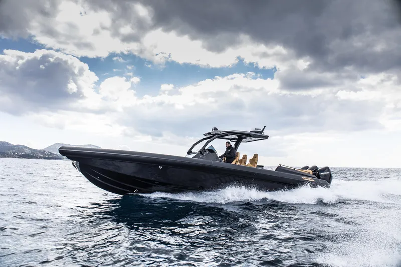 Slide: The Image of 2024 Skipper-BSK 38NC luxury speedboat cruising on open water under cloudy sky. - 0