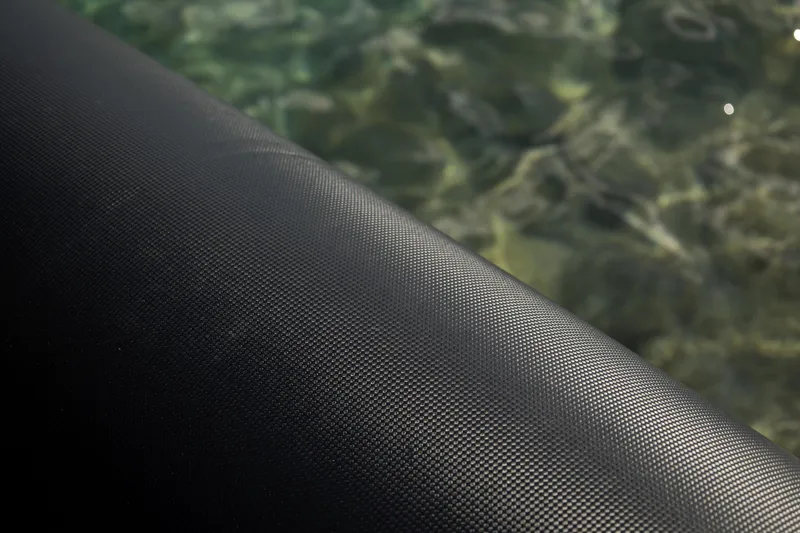 Slide: The Image of Close-up of Skipper-BSK 38NC 2024 boat's textured black surface near water. - 21