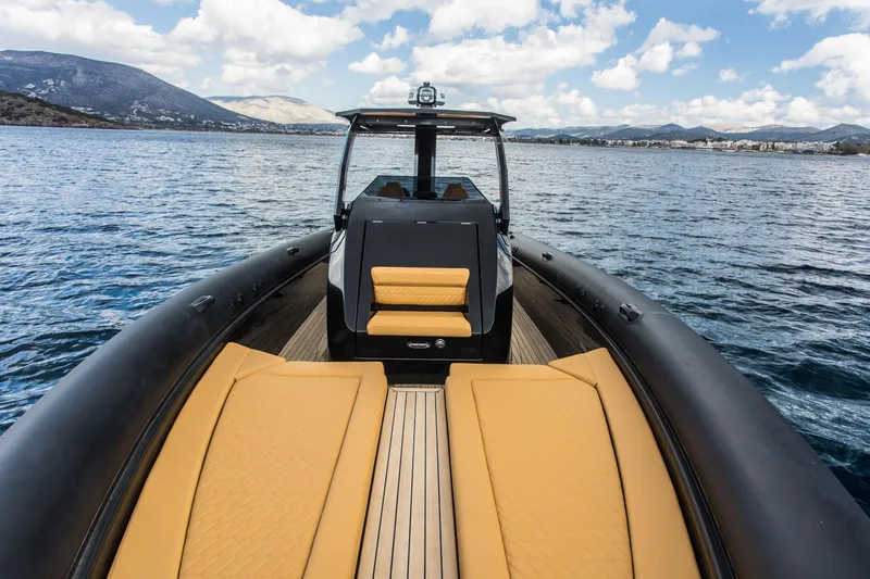 Slide: The Image of 2024 Skipper-BSK 38NC luxury boat on calm waters with scenic mountain backdrop. - 36