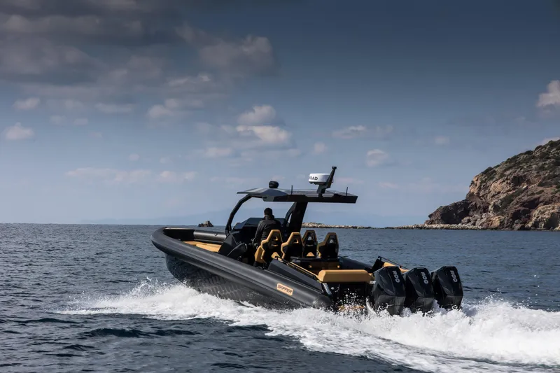 Slide: The Image of 2024 Skipper-BSK 38NC boat cruising on open water near rocky coastline. - 5