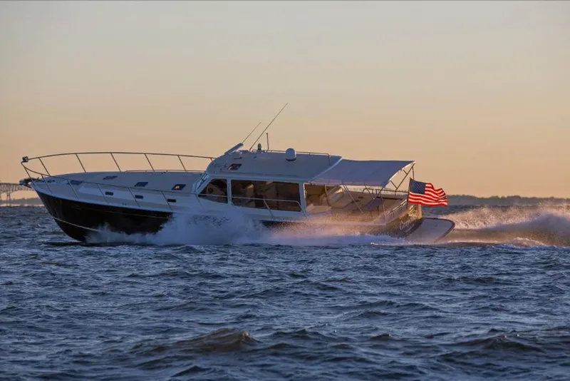 Slide: The Image of 2023 MJM 50z yacht cruising at sunset with American flag. - 14