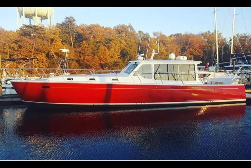 Slide: The Image of 2023 MJM 50z yacht with a red hull docked in a marina during autumn. - 24