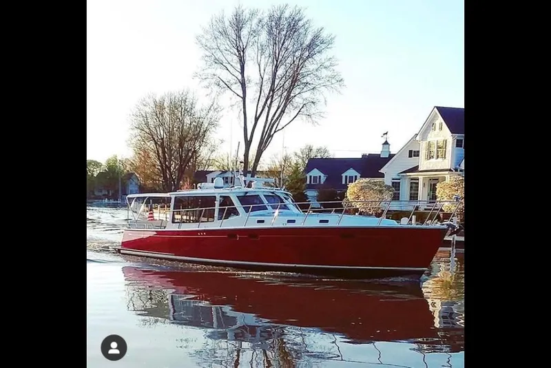 Slide: The Image of 2023 MJM 50z yacht cruising on a calm river near waterfront homes. - 25