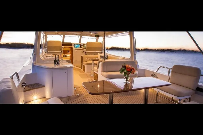 Slide: The Image of Luxurious interior of 2023 MJM 50z yacht at sunset, featuring elegant seating and a dining area. - 32