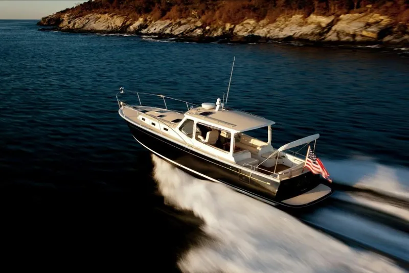 Slide: The Image of 2023 MJM 40z luxury yacht cruising on open water near rocky coastline. - 12