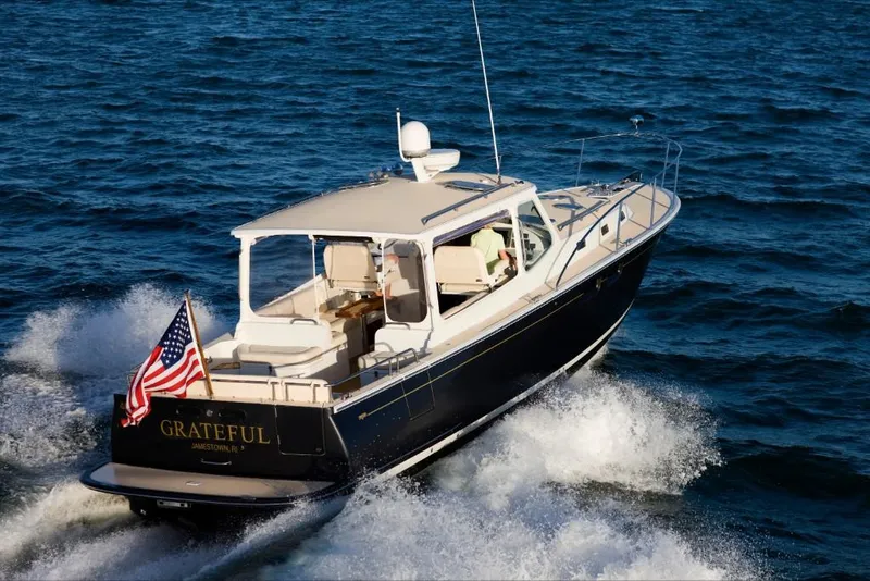 Slide: The Image of 2023 MJM 40z yacht cruising on open water with American flag. - 6
