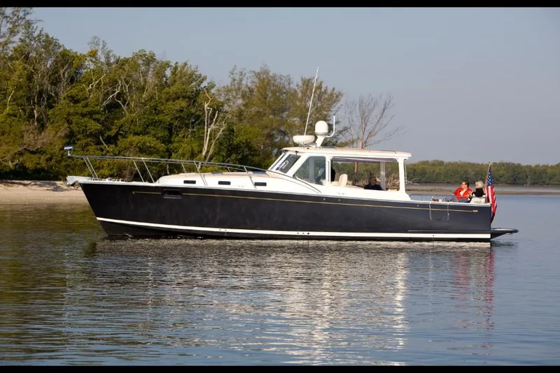 Slide: The Image of 2023 MJM 40z yacht cruising near a forested shoreline. - 8