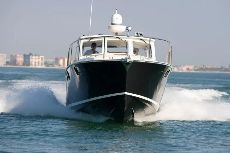 Slide: The Image of 2023 MJM 40z boat cruising on water with cityscape in background. - 9