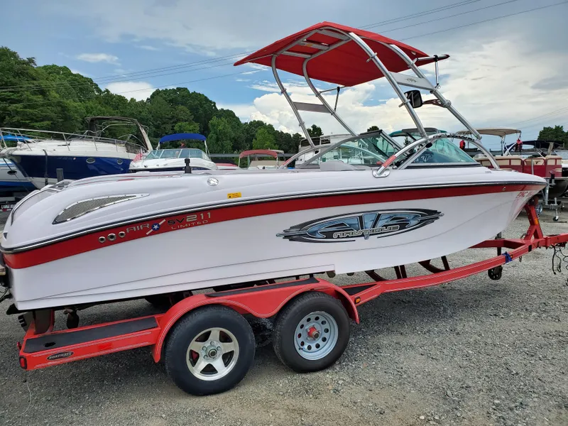 The Image of 2005 Correct Craft SV-211 Limited boat on red trailer, parked outdoors. - 0